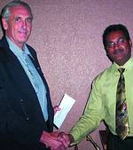 Peter Grant, chairman of the executive committee of Pretoria Sungardens Hospice accepts a cheque from money raised at last year&#8217;s golf day from Kris Pillay, chairman of SAIS